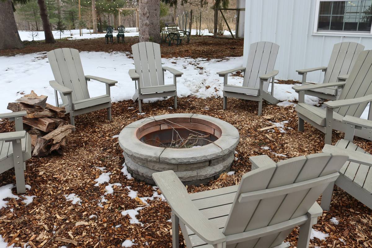outdoor fireplace furniture ideas featuring heat-resistant sectional seating arranged around a stone fire pit