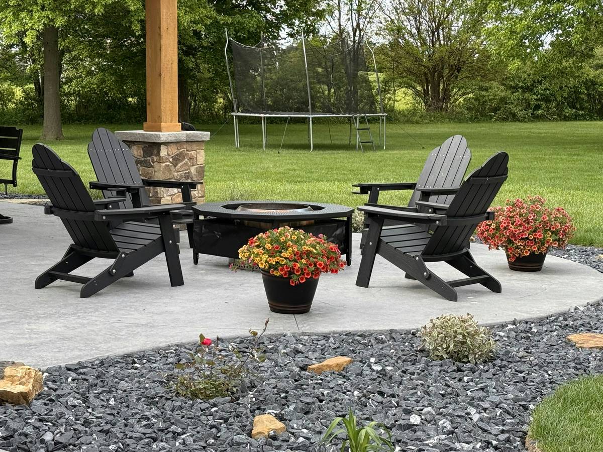 Modern outdoor furniture with propane fireplace featuring integrated seating and concealed tank, placed on a stone patio